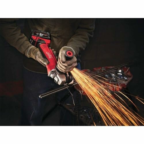 Person using an angle grinder with sparks flying.