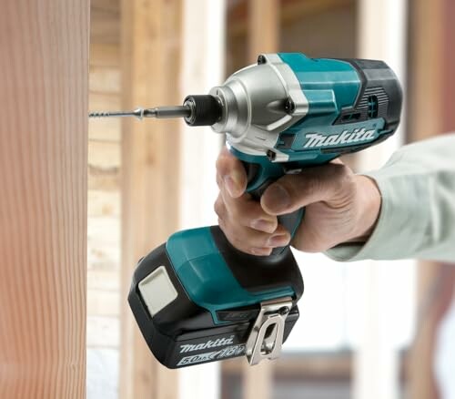 Person using a cordless power drill on wood