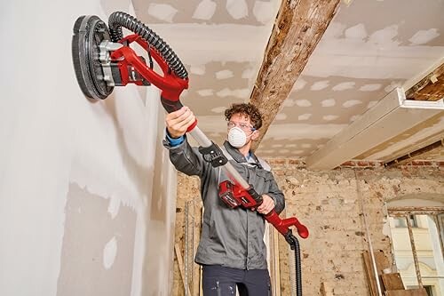 Person using a drywall sander in a renovation project