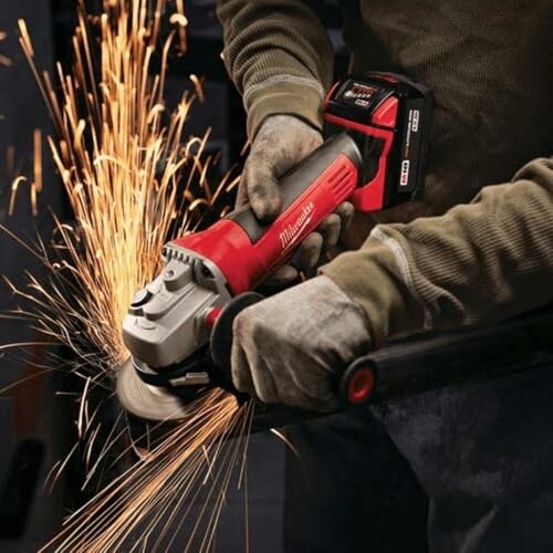 Person using an angle grinder with sparks flying.